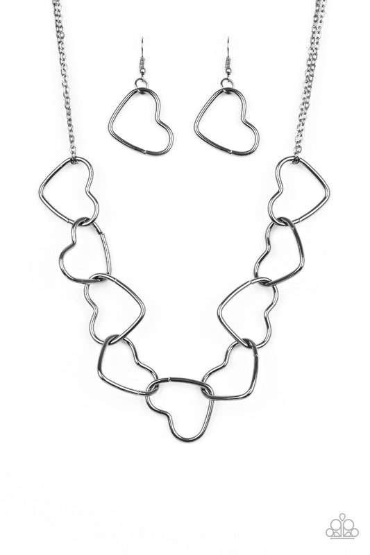 Paparazzi Unbreak My Heart - Black Necklace Airy gunmetal heart silhouettes connect below the collar for a flirtatious look. Sold as one individual black necklace. Includes one pair of matching earrings.
