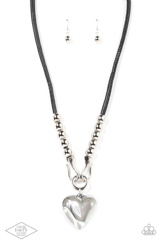 Paparazzi Forbidden Love - Black Necklace - Black Pendant Necklace Chunky silver beads, a silver heart pendant swings from a silver hook-like fittings that attach to a bold leather cord across the chest for a heartbreaker look. Sold as one individual black pendant necklace.