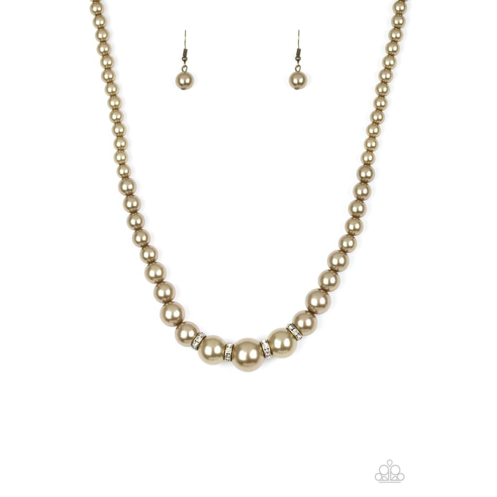Paparazzi Party Pearls - Brass Necklace Pearly brass beads trickle below the collar for a classic look. Dazzling white rhinestones, glittery rings are sprinkled between the pearly beads for a timeless finish. Sold as one individual brass necklace. Includes one pair of matching earrings.
